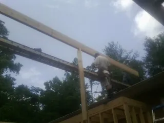 Carpenter setting a ridge beam over a new addition frame — Ice Dam Removal by Roofing Brothers in Elk Mound