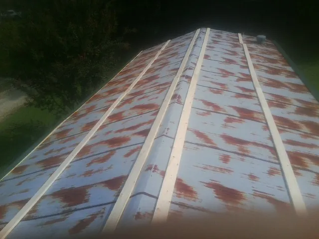 Rusted metal roof panels with new wood purlins before replacement — Storm Damage Roof Repair in Elk Mound by Roofing Brothers